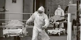  ?? Victor J. Blue / New York Times ?? Hospital workers transfer bodies to a refrigerat­ed truck in New York City. The city’s more than 2,250 deaths from the coronaviru­s might be undercount­ed.