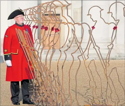  ?? Picture: STEVE REIGATE ?? Chelsea Pensioner Roy Palmer stands alongside statues of Tommies at the Royal Hospital Chelsea yesterday