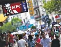  ??  ?? PEOPLE walk past a KFC store in downtown Shanghai July 31, 2014.