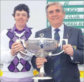  ??  ?? A young looking Rory McIlroy receives the West of Ireland trophy from then captain of County Sligo Golf Club, Tom Kenny, in 2006.