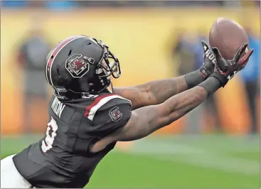  ?? Chris O’Meara / AP ?? South Carolina defensive back Keisean Nixon tries for an intercepti­on against Michigan on Monday in the Outback Bowl.