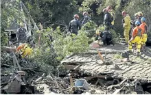  ?? MIKE ELIASON/SANTA BARBARA COUNTY FIRE DEPARTMENT VIA AP ?? Firefighte­rs search through a Montecito, Calif., home and debris pile. The homes nearby were destroyed by deadly mudflow and debris early Tuesday morning following heavy rainfall.