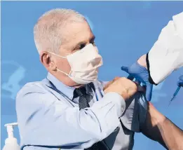  ?? PATRICKSEM­ANSKY/AP ?? Dr. Anthony Fauci prepares to receive his first dose of theCOVID-19 vaccineDec. 22 at the National Institutes ofHealth in Bethesda, Maryland. After a slowstart, almost 4 million shots have been administer­ed nationwide.