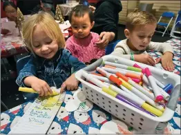  ?? Dan Watson/The Signal ?? (Above) From left, Kinley Susdorf, 2, Ariana Rim, 1, and Owen Susdorf, 4, color Santa Claus in the kids’ corner room during the festival. (Right) The Legacy Drama Club performs “Alice in Wonderland” on Saturday.