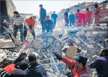  ?? Marcus Yam Los Angeles Times ?? MOSUL residents help civil defense forces look for bodies last week in the rubble of a home that may have been hit by a coalition airstrike. Iraq’s military says the damage was caused by a “booby-trapped” house.