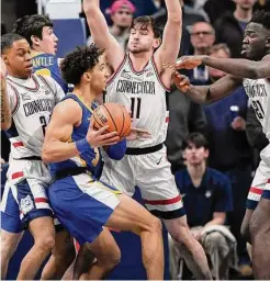  ?? Jessica Hill/Associated Press ?? Xavier’s Colby Jones is guarded by UConn’s Jordan Hawkins, left, Alex Karaban, center, and Adama Sanogo, right, in the first half of an NCAA college basketball game Jan. 25 in Storrs.