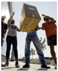  ?? MATT ROURKE / ASSOCIATED PRESS ?? Volunteers move boxes of shoes that were donated for students affected by Hurricane Harvey on Wednesday in Houston. Organizati­ons across the state and nation are helping in the relief effort.