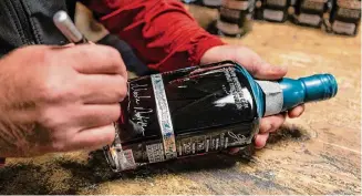  ?? Salgu Wissmath/Staff photograph­er ?? Master Distiller Donnis Todd signs a bottle at Garrison Brothers Distillery in Hye, the first legal whiskey distillery in Texas.