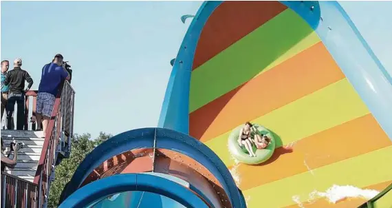  ?? Rich Pope / Orlando Sentinel ?? On Aquatica Orlando’s newest waterslide, KareKare Curl, two riders, who face each other on the raft, experience a 35-foot drop in the enclosed tube and then rush up a vertical wave wall.