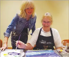  ?? BARB AGUIAR/Westside Weekly ?? Above: Instructor Louise Lambert gives Jeanne Bates some tips on her water lily painting. Below: Lambert demonstrat­es how to start painting.