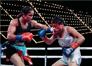  ?? (Getty) ?? Serrano punches Erika Cruz during their title fight at the Theatre at Madison Square Garden on Saturday
