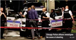  ?? PIC: AFP ?? Chicago Police officers investigat­e the scene of shooting.