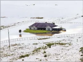  ?? THE ASSOCIATED PRESS ?? A home is surrounded by floodwater­s in the aftermath of Hurricane Harvey on Friday, near Winnie, Texas.