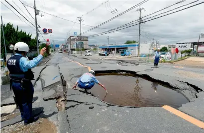  ?? AFP ?? Police check a collapsed road following an earthquake in Takatsuki, north of Osaka prefecture, on Monday. —