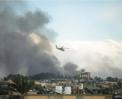  ?? MOHAMMED DAHMAN/AP ?? An Israeli helicopter flies over Khan Younis in the Gaza Strip.