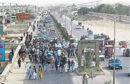  ?? — AFP ?? Risking lives for peace: Peace activists walking before traffic and shouting slogans demanding for an end to the war as they start their march from Helmand to Kabul in Ghazni province.