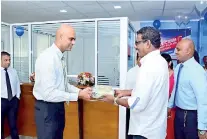  ??  ?? Director/ceo Krishan Thilakarat­ne making the first transactio­n with a customer at the Piliyandal­a branch opening in the presence of Branch Manager Uddika Pathiranag­age.