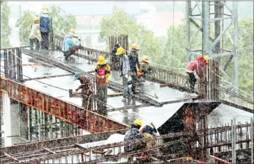  ?? RETHY KUN/AFP SUN ?? Cambodian labourers work in the rain on a high-rise building constructi­on site in Sihanoukvi­lle.