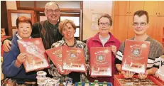  ?? FOTO: UWE MISERIUS ?? Unerwartet­e Dreingabe: Brigitte Steinke (l.) und Pfarrer Ulrich Sander freuen sich mit dem Tafel-Team Quettingen über die Werkself-Kalender.