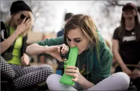  ?? @TMartinHer­ald Herald file photo by Tijana Martin ?? Chantel Haeberle uses a bong to smoke marijuana during the “420@ThePark” event at Galt Gardens Park earlier this spring.