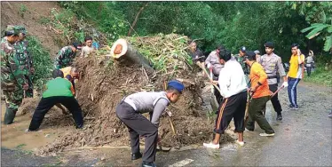  ?? POLSEK PANGGUL FOR JAWA POS RADAR TRENGGALEK ?? KERJA SAMA: Aparat dan warga menyingkir­kan sisa material longsor di Desa Ngrencak, Kecamatan Panggul.