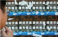  ?? (Bobby Yip/Reuters) ?? A STUDENT VIEWS posters demanding independen­ce for Hong Kong at the Chinese University of Hong Kong on September 8.