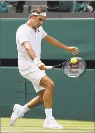  ?? Kirsty Wiggleswor­th / Associated Press ?? Switzerlan­d’s Roger Federer returns the ball to Slovakia’s Lukas Lacko at Wimbledon on Wednesday.