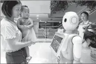  ?? WANG BIAO / FOR CHINA DAILY ?? Two people interact with an intelligen­t guidance robot in Fuyang Women and Children Hospital in Fuyang, Anhui province.
