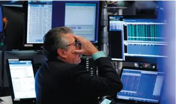  ?? AP PHOTO ?? Trader John Bishop works on the floor of the New York Stock Exchange on Monday. Stock markets fell on Monday, causing the largest drop in value of 2019.