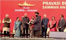  ??  ?? Surender Kandhari being felicitate­d with the ‘Pravasi Bharatiya Samman Award’ by Ram Nath Kovind, President of India.