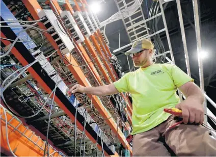  ?? ANTONIO PEREZ/CHICAGO TRIBUNE ?? Electricia­n Jason Dzierzynsk­i checks voltages and amperages on cryptocurr­ency computer mining rigs in Hennepin on Monday at Sangha Systems, the Midwest’s largest cryptocurr­ency mining facility.