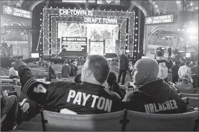  ?? CHRIS SWEDA/CHICAGO TRIBUNE ?? Bears fans Tim McCarthy, left, and Justin Carlson, right, take in the scene before the NFL draft in Chicago on April 30, 2015.