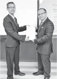  ??  ?? WASININ (kiri) menyampaik­an sijil kursus kepada Suhaimi.