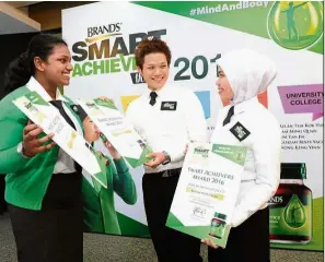  ??  ?? Three of the award recipients share a light moment after the presentati­on ceremony.