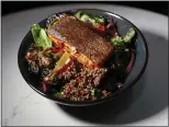  ??  ?? The salmon and quinoa bowl also includes veggies drizzled with sweet Thai chile sauce.