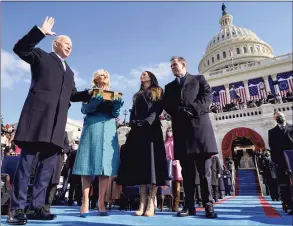  ?? Andrew Harnik / Associated Press ?? Joe Biden is sworn in as the 46th president of the United States by Chief Justice John Roberts as Jill Biden holds the Bible during the 59th Presidenti­al Inaugurati­on at the U.S. Capitol in Washington on Jan. 20, as their children Ashley and Hunter watch.