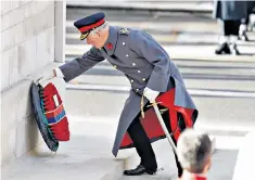  ??  ?? The Prince of Wales places a wreath on the Cenotaph on behalf of the Queen; above, the ceremony at the foot of the memorial in central London. Right, a young girl carries a photograph on the ‘People’s Procession’