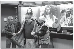  ?? AP/PATRICK SEMANSKY ?? Vernon Finley (left) and Tony Incashola present Attorney General William Barr with a blanket during Barr’s visit to the Flathead Reservatio­n in Pablo, Mont.