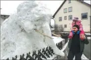  ?? THOMAS WARNACK / DPA VIA AFP ?? A man and a child look at an elephant made of snow and wooden sticks in Duernau, Germany, on Feb 23.