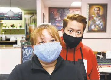  ?? Arnold Gold / Hearst Connecticu­t Media ?? Rachanee Netsuwan, left, and her brother, Paul, in their restaurant, Sri Thai, in West Haven, wearing face masks Rachanee Netsuwan makes in a corner of the restaurant.