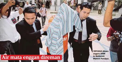  ??  ?? TERTUDUH dibawa anggota SPRM ke Mahkamah Majistret Putrajaya.