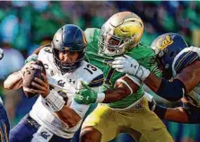  ?? Michael Conroy/Associated Press 2022 ?? Notre Dame defensive end Isaiah Foskey (center) capitalize­d on NIL after such deals became permissibl­e in July 2021.