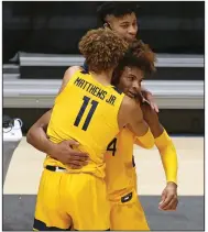  ?? (AP/Kathleen Batten) ?? West Virginia forward Emmitt Matthews Jr. (11) and guard Miles McBride (4) celebrate after McBride made the winning shot against Texas Tech on Monday night in Morgantown, W.Va.