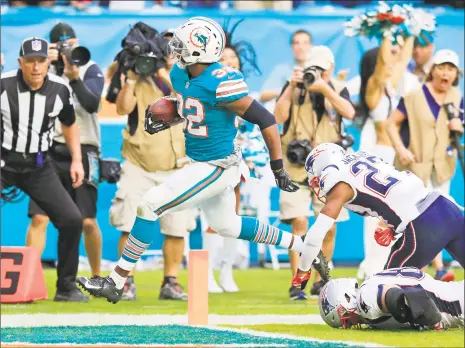  ?? Al Diaz / TNS ?? Kenyan Drake of the Dolphins scores the game-winning touchdown to defeat the Patriots on Sunday in Miami Gardens, Fla.