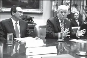  ?? Evan Vucci/AP ?? GOP: Treasury Secretary Steve Mnuchin listens as President Donald Trump speaks during a meeting on tax policy with business leaders in the Roosevelt Room of the White House, Tuesday in Washington.