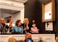  ??  ?? Shocked people watch Banksy’s Girl With Balloon painting selfdestru­ct moments after it was sold at Sotheby’s auction.