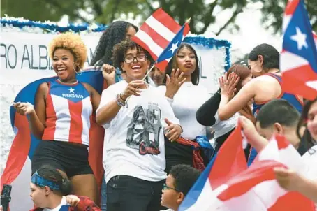  ?? CHRIS SWEDA/CHICAGO TRIBUNE ?? People dance on a float Saturday during the annual Puerto Rican People’s Day Parade on Division Street in Chicago’s Humboldt Park neighborho­od.
