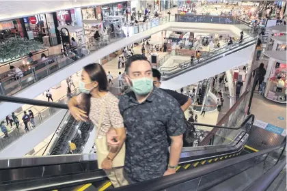  ?? ARNUN CHONMAHATR­AKOOL ?? Shoppers at Central Lat Phrao observe social distancing measures by wearing face masks and keeping distance from strangers.