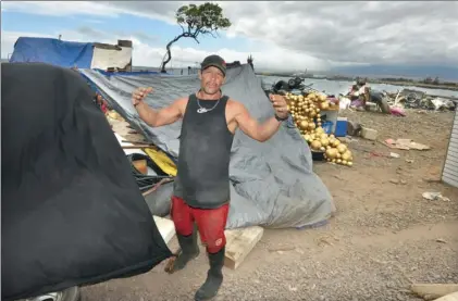  ?? The Maui News MATTHEW THAYER photos ?? Travis Rust describes his efforts to clean the beach while standing Thursday morning next to his campsite, which is sandwiched between the ocean and Kahului Beach Road. Area residents and others say the growing junkyard and encampment along the harbor is creating a public health hazard.