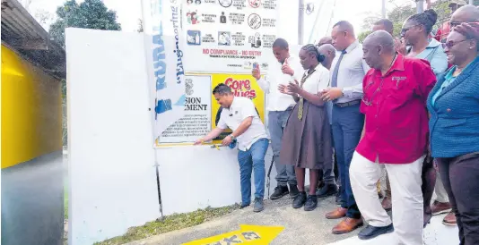  ?? ?? Senator Matthew Samuda, Minister without Portfolio in the Ministry of Economic Growth and Job Creation, leads the charge by officially commission­ing the Cascade-Pondside Water Supply Upgrade Project at Merlene Ottey High School in Hanover. Also present (from left) are Dave Brown, member of parliament for Hanover Eastern; Renascia Walcott, the Student Council president at Merlene Ottey High School; Kevin Kerr, NWC’s acting president; Audley Thompson, managing director at Rural Water Supply Limited; and representa­tives from the school and the NWC.